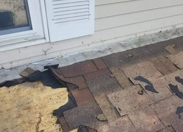 Wind-torn shingles exposing the roof deck, found on an All-American inspection