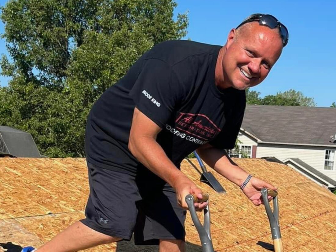 Brad VanBibber tearing off a roof during a replacement, shovels in hand